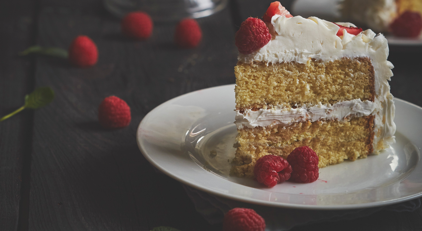 Vanilla butter cake on plate garnished with raspberries