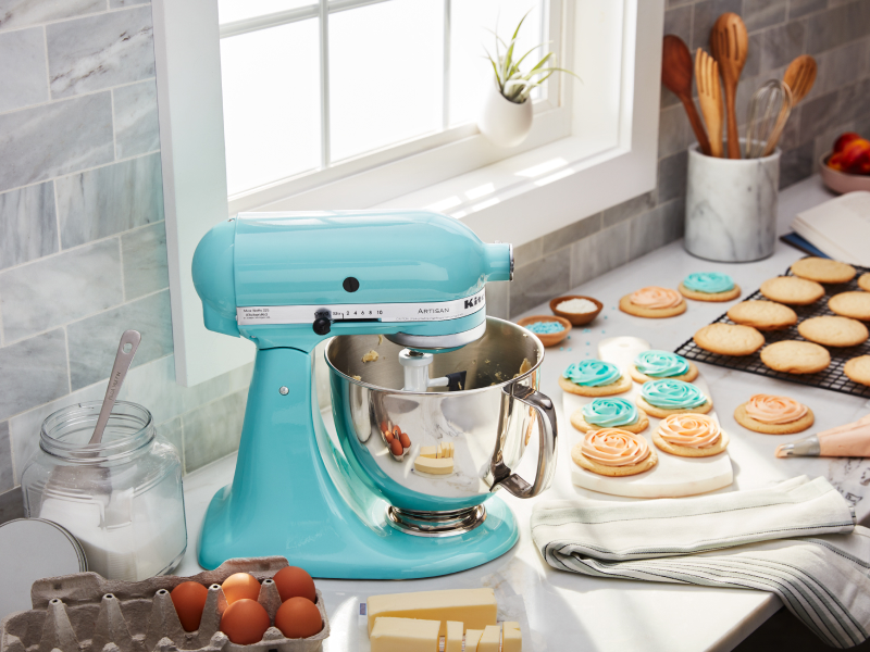 Bright blue KitchenAid® stand mixer next to decorated sugar cookies