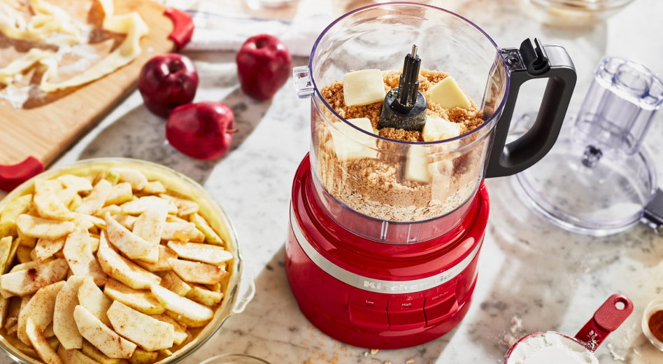 Bowl of apple slices and food processor filled with flour and cubes of butter