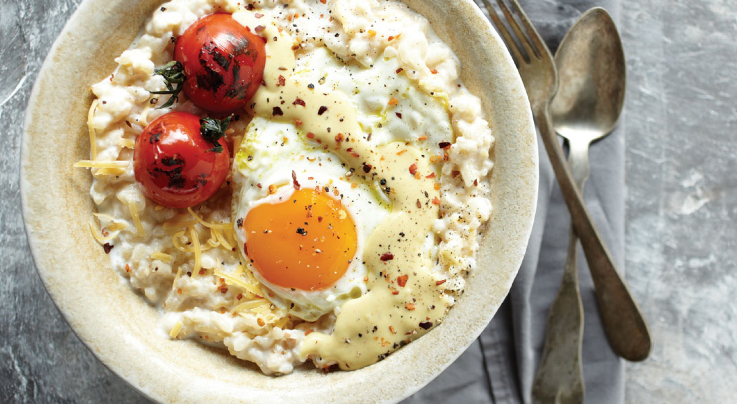 Risotto topped with grape tomatoes and a fried egg
