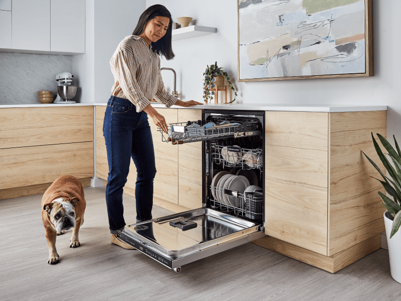 Person loading a KitchenAid® dishwasher