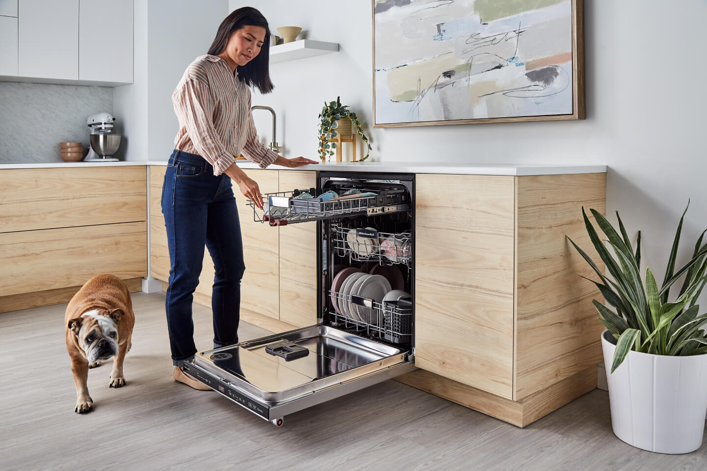 Person loading a KitchenAid® dishwasher