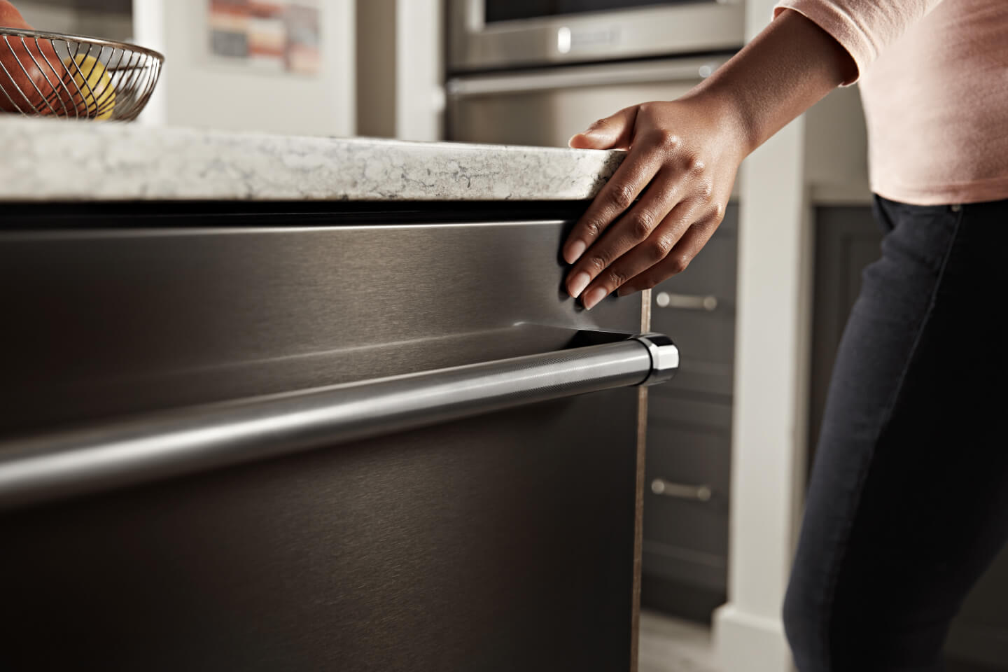 Person closing a KitchenAid® top control dishwasher