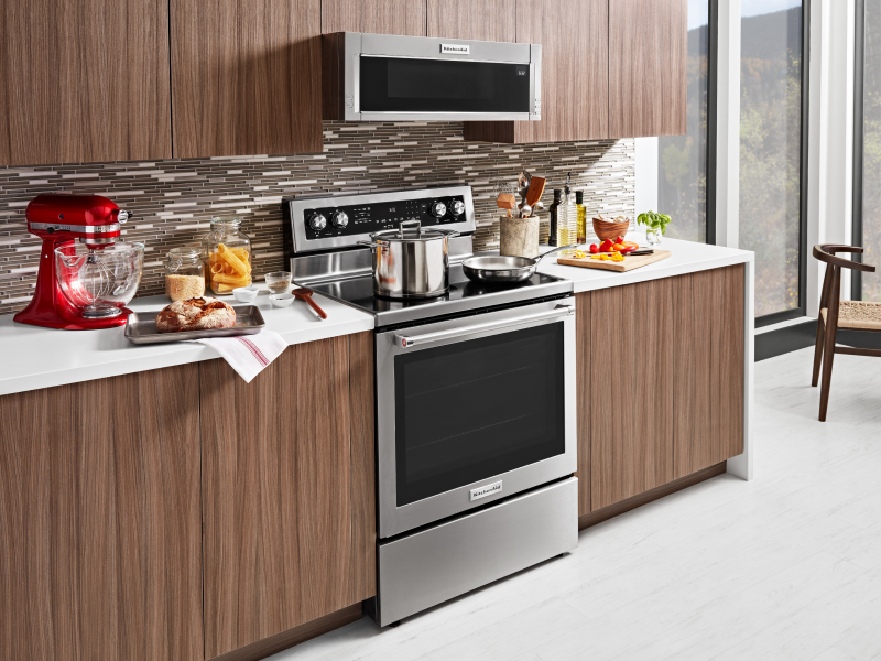 A stainless steel KitchenAid® slide-in range next to prepared dishes 