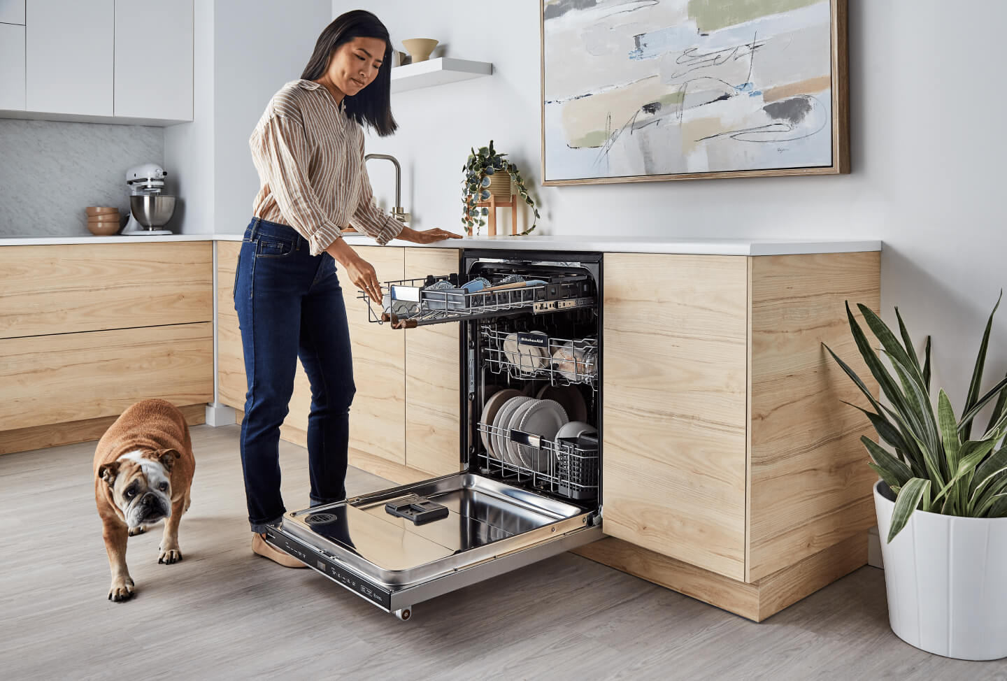 Person picking up dirty bowl to load into dishwasher