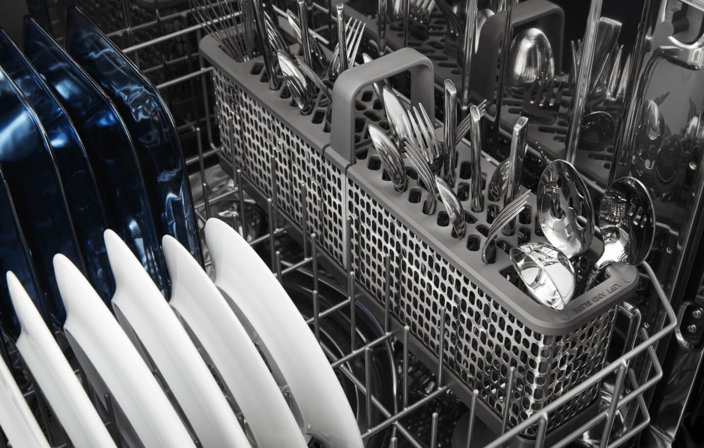 Clean plates and silverware in a dishwasher after a cycle