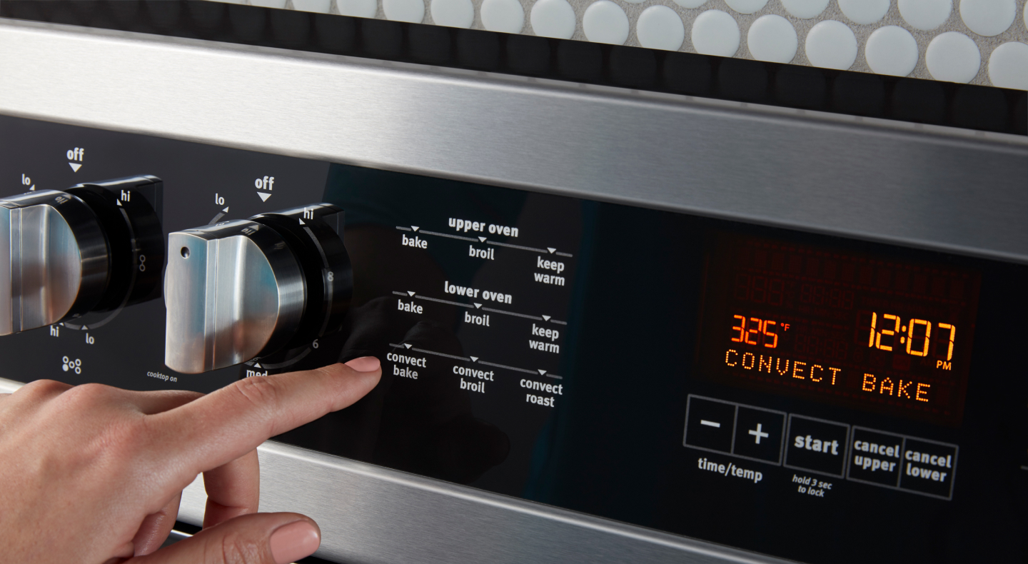 Person pressing buttons on a range