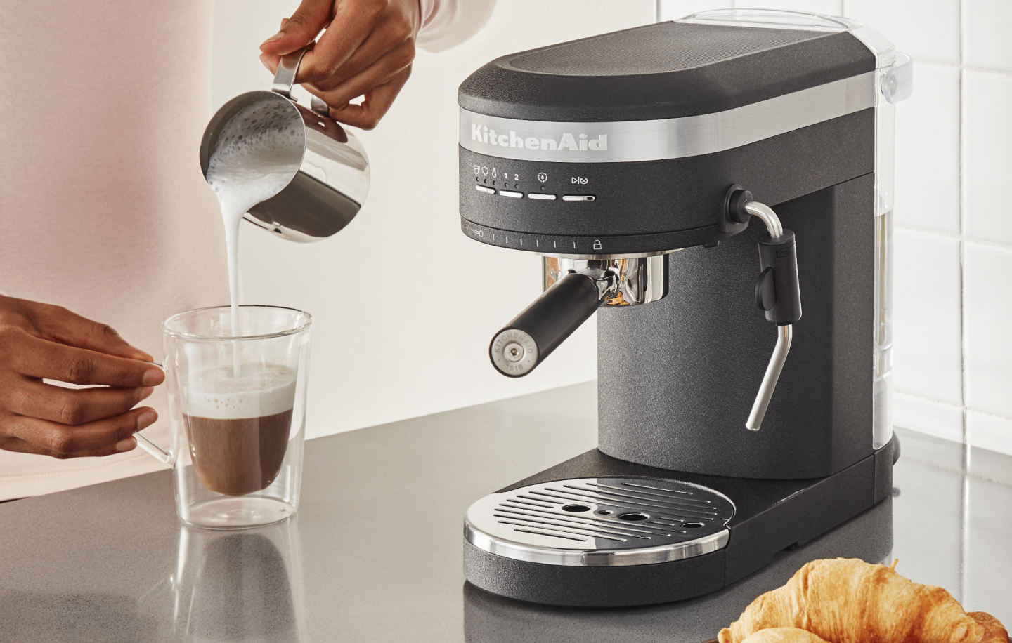 Steamed milk being poured over espresso