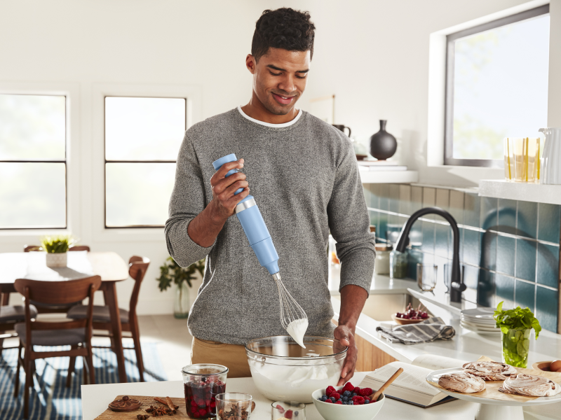 Man whipping cream with a hand blender
