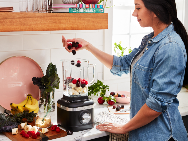 Person adding fruit to a blender