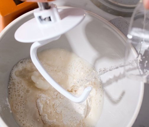 Water streaming into a stand mixer bowl