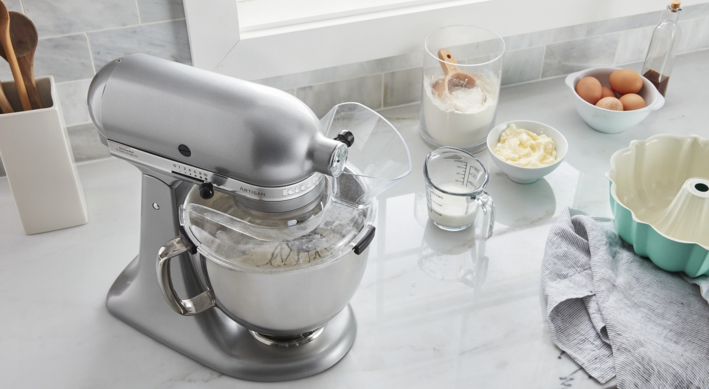 Stainless steel stand mixer next to to cake batter ingredients