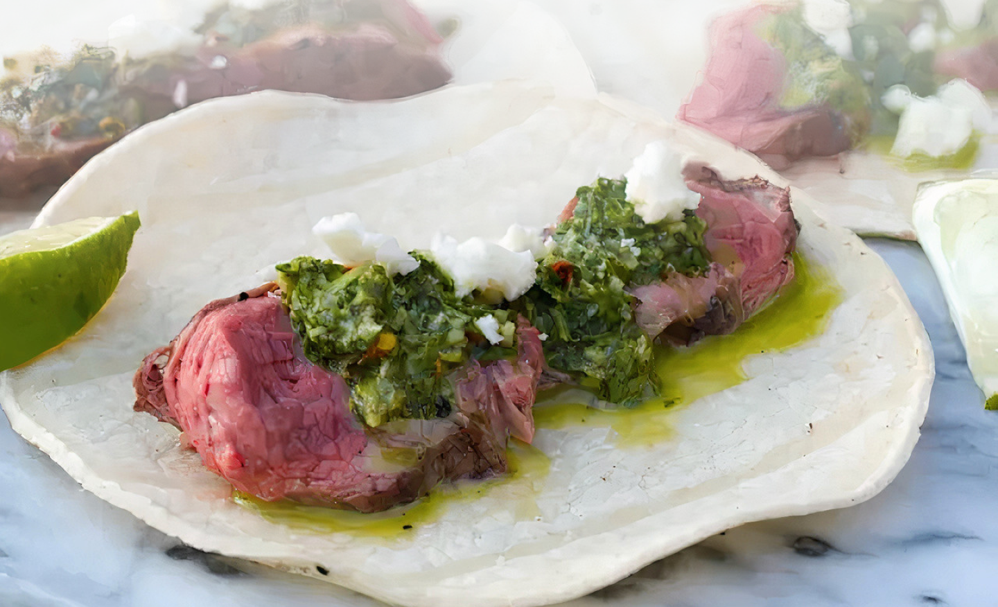 Steak tacos topped with chimichurri