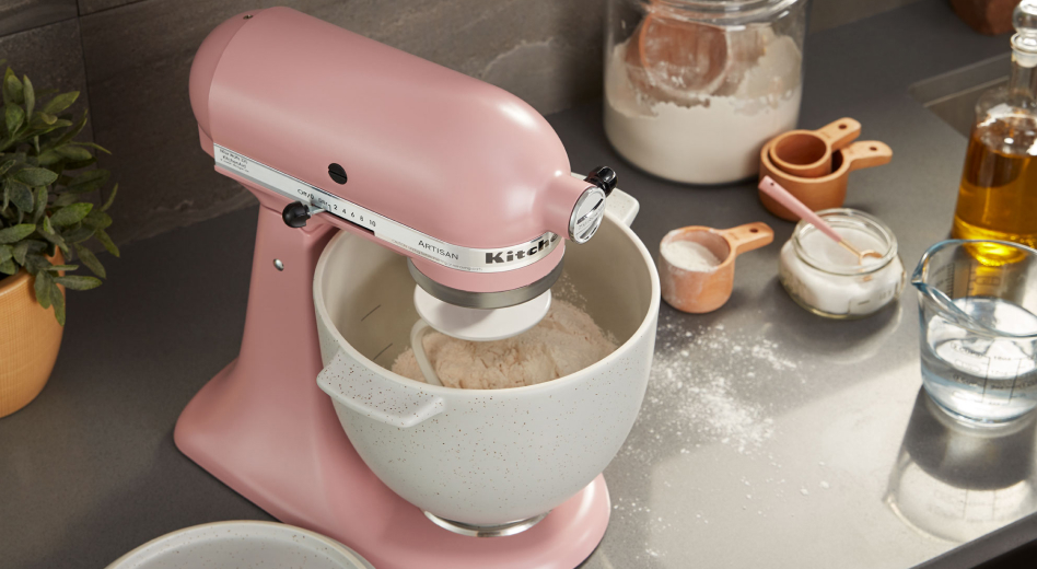 Silk Pink stand mixer kneading bread dough, surrounded by ingredients