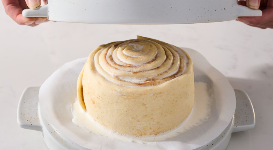 Person covering cinnamon roll bread dough to bake
