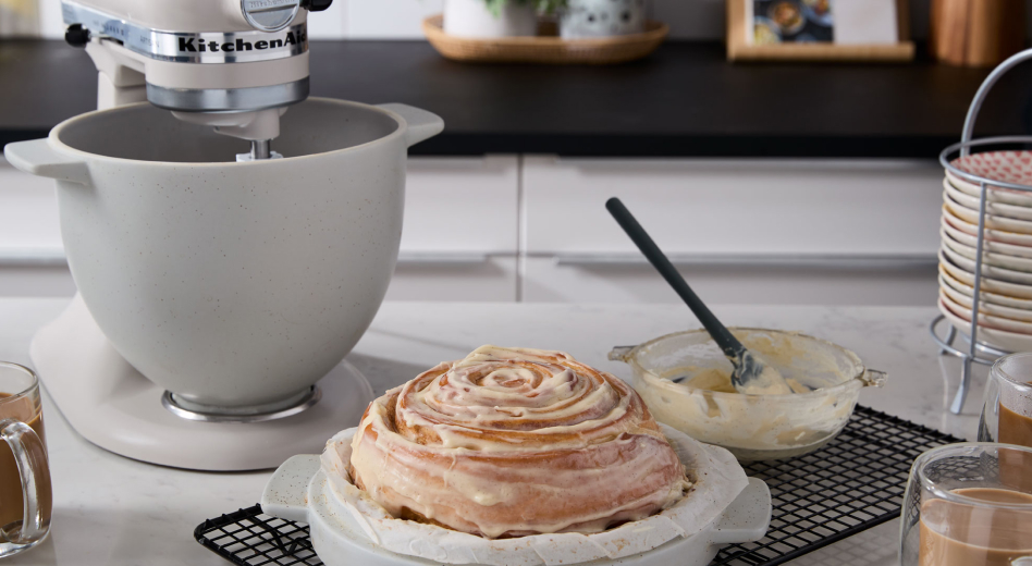 KitchenAid® stand mixer with Bread Bowl accessory next to cinnamon roll bread