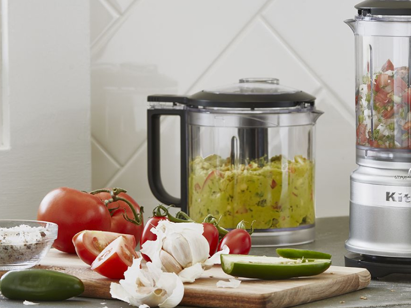 Guacamole and salsa in food processors on counter