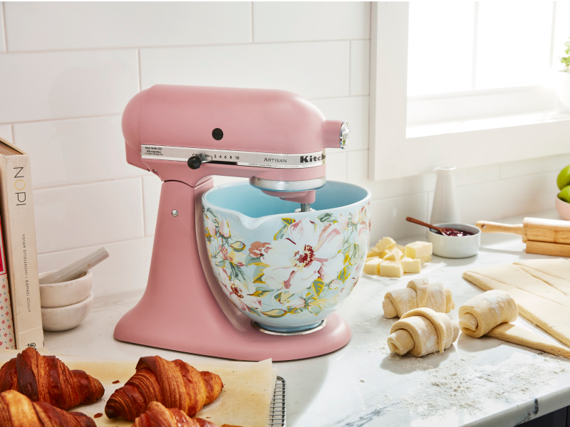 Pink KitchenAid® stand mixer with patterned bowl next to croissant dough