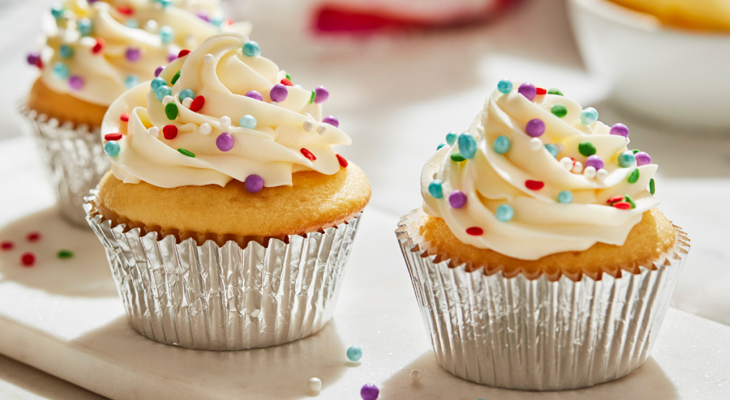 Cupcakes frosted with buttercream frosting and decorative sprinkles
