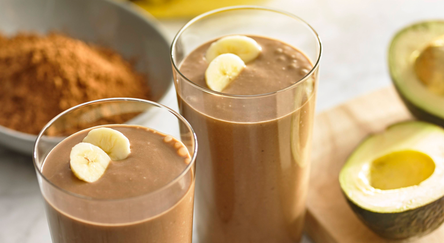 Glasses filled with chocolate smoothie and topped with banana slices