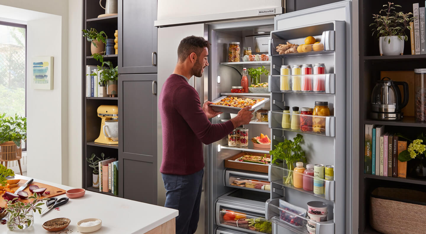 Man pulling sheet of fresh pasta from refrigerator