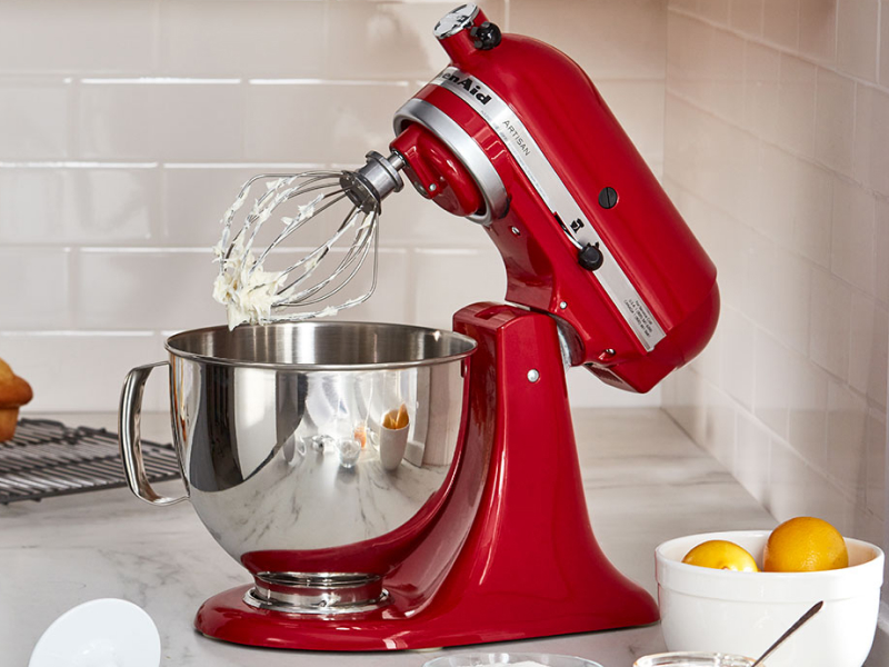 Red KitchenAid® stand mixer with stainless steel bowl and wire whisk attachment