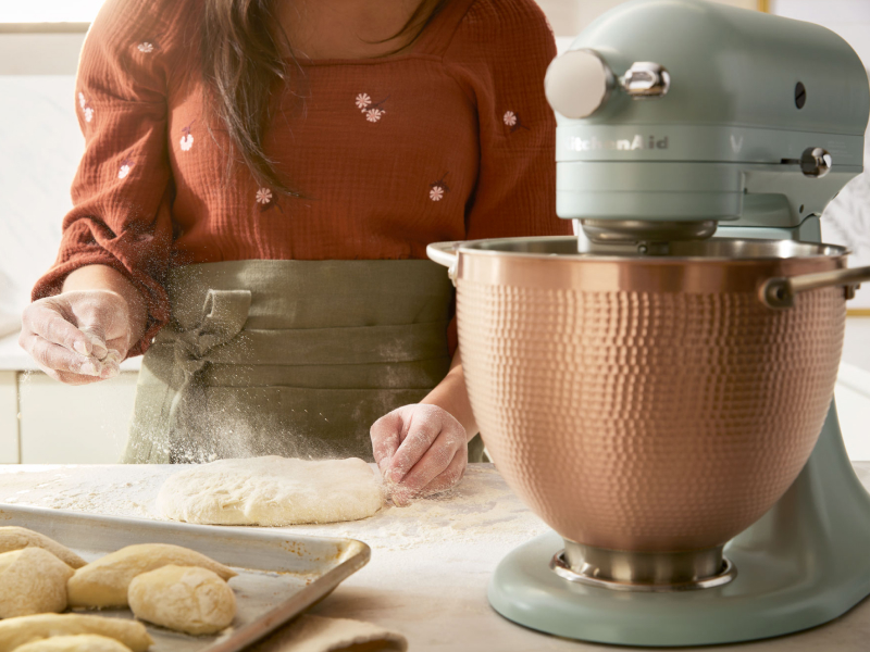 Scone dough being sprinkled with flour next to  KitchenAid® stand mixer
