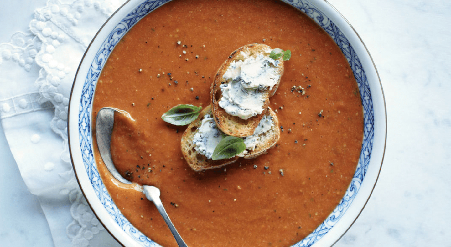 Top view of blended soup in bowl with toasted bread on top