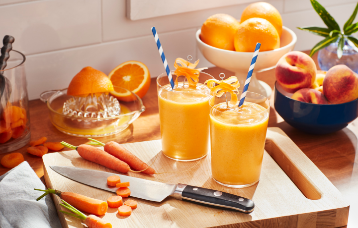 Orange smoothies in a glass on a cutting board
