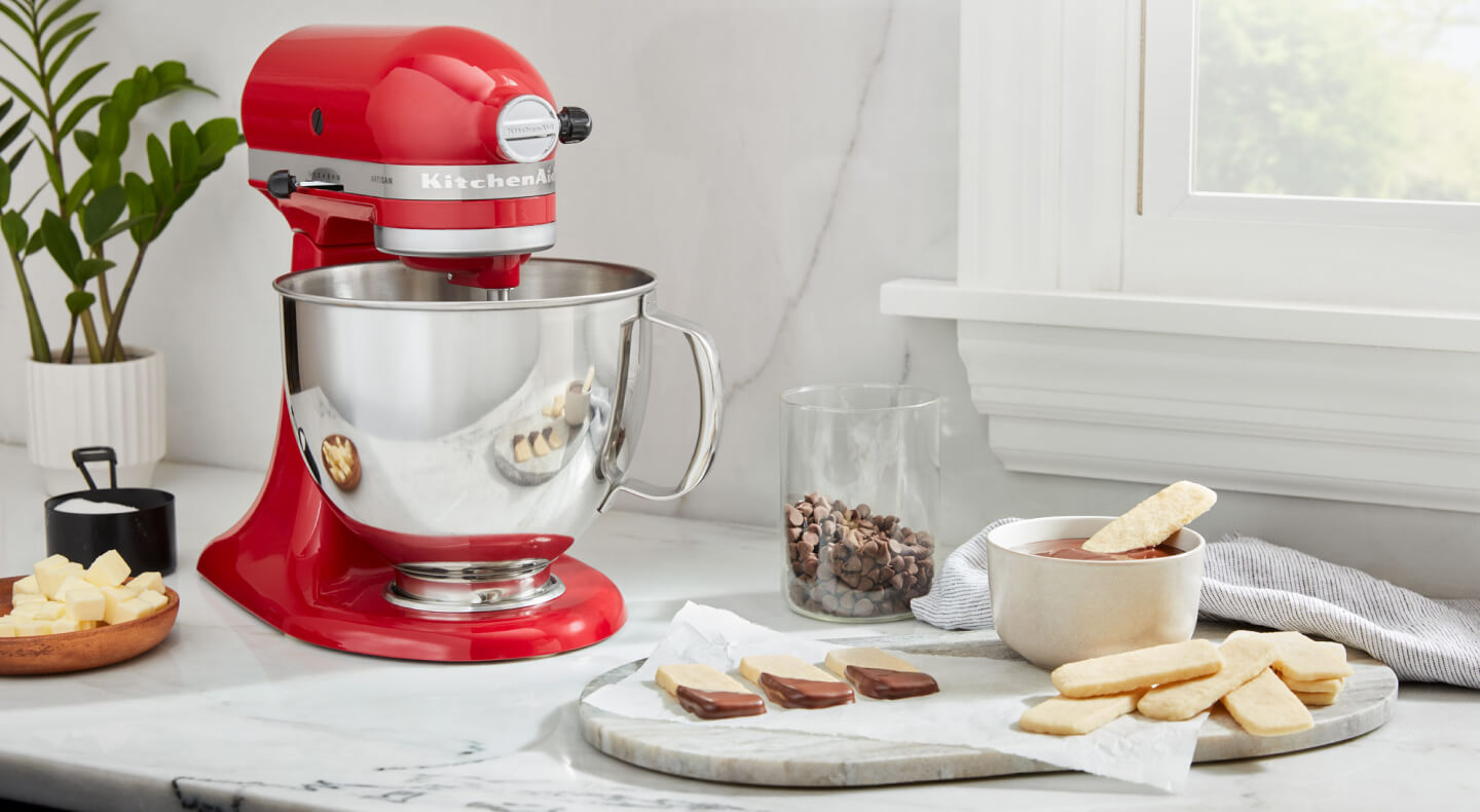 A red KitchenAid® stand mixer and a prepared dessert on a countertop 