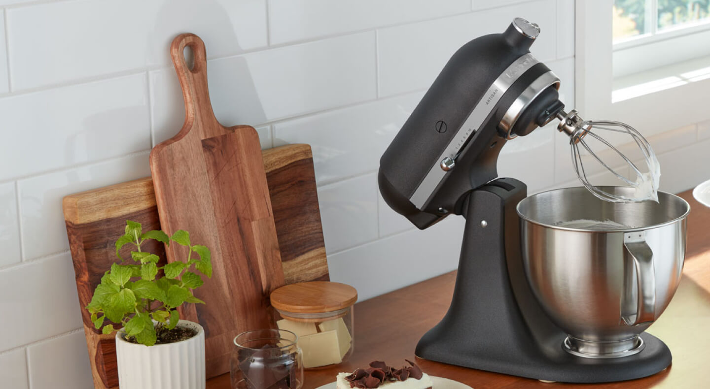 A black KitchenAid® stand mixer and various kitchen items on a countertop 
