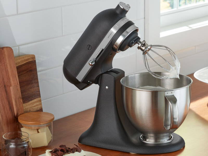 A black KitchenAid® stand mixer and various kitchen items on a countertop 
