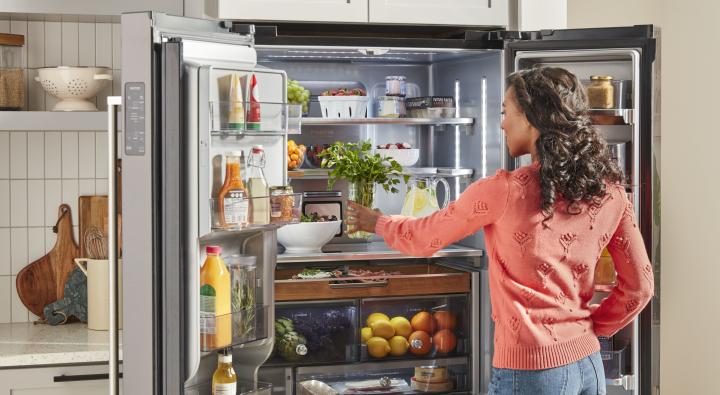 Person placing produce in a refrigerator