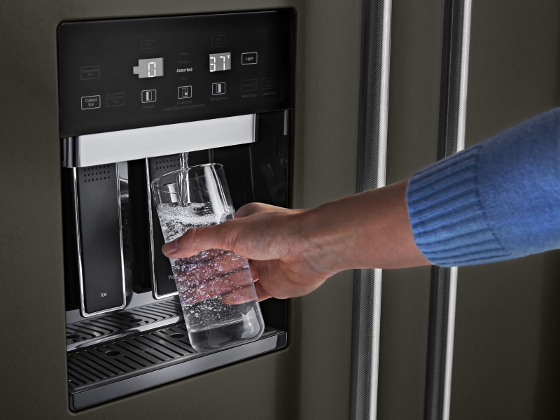 Person filling water from refrigerator dispenser