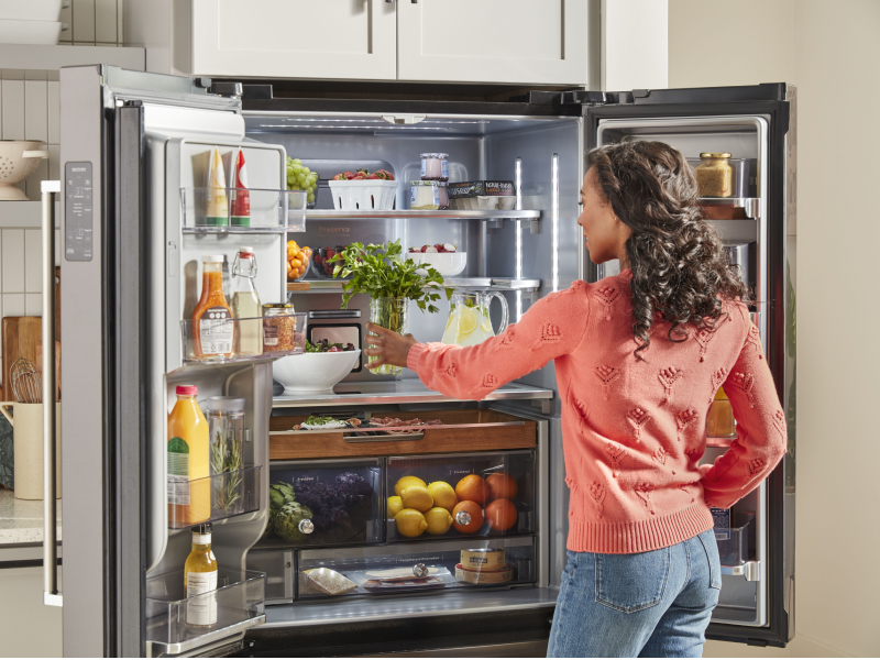 Person placing produce in a refrigerator