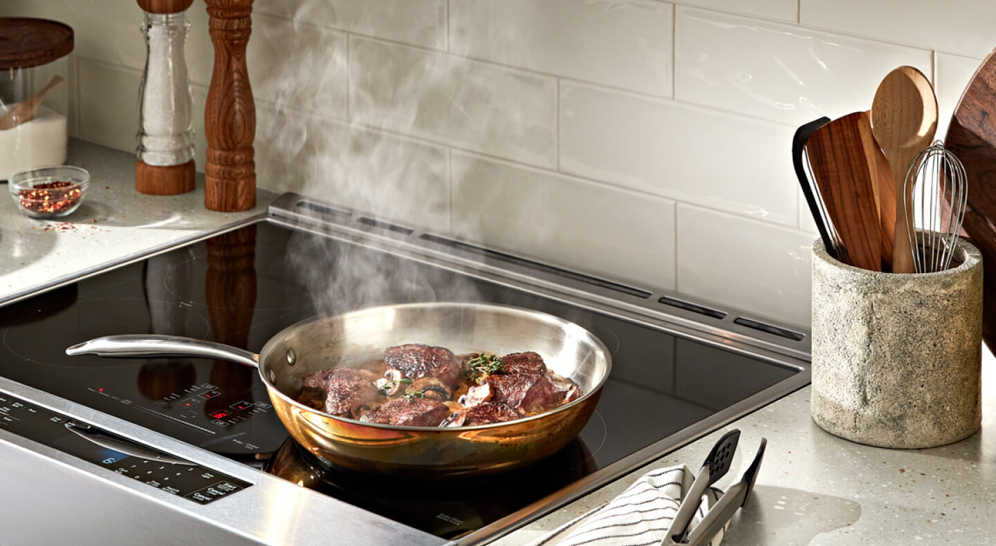 Steak cooking on a cooktop
