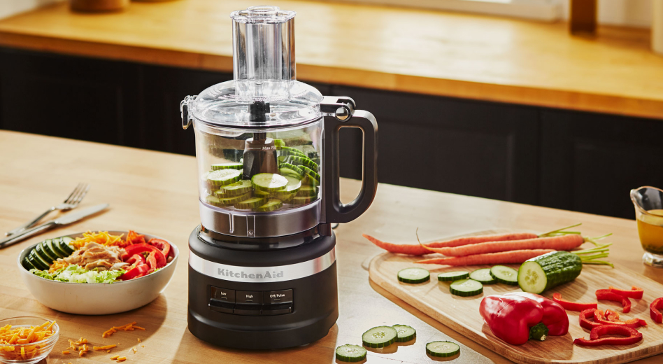 Sliced cucumbers inside a black KitchenAid® food processor