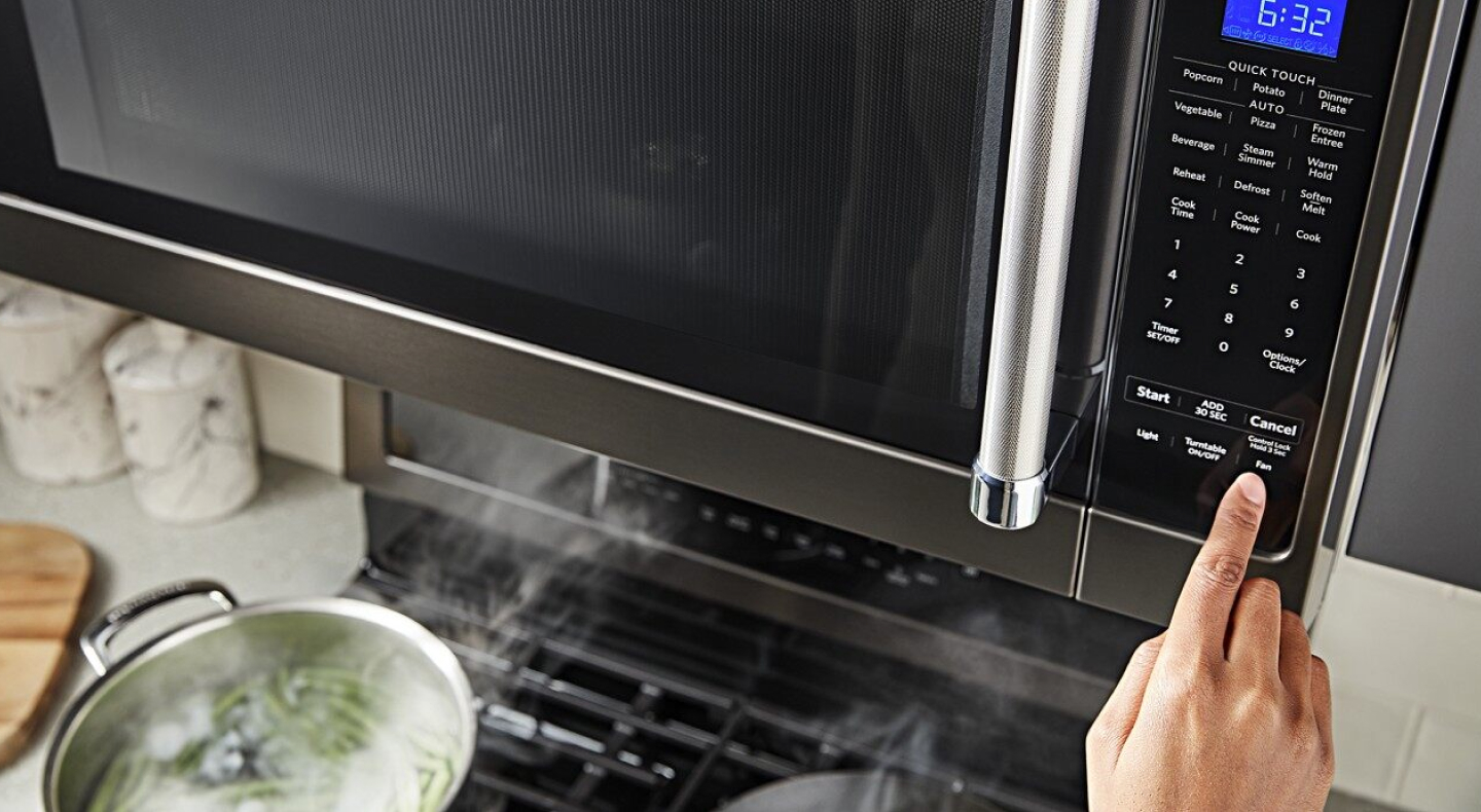 Person selecting a microwave preset button