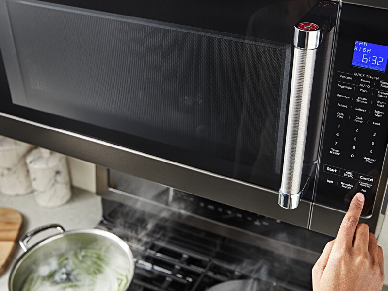 Person selecting a microwave preset button