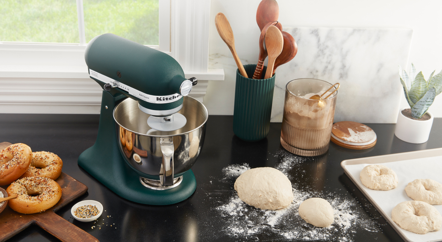 Bagel dough on a countertop next to a blue-green KitchenAid® stand mixer