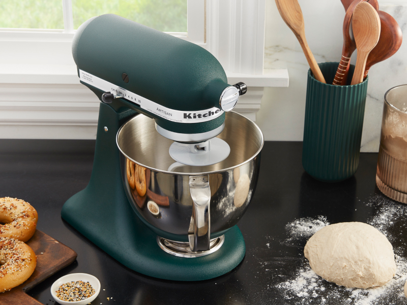 Bagel dough on a countertop next to a blue-green KitchenAid® stand mixer
