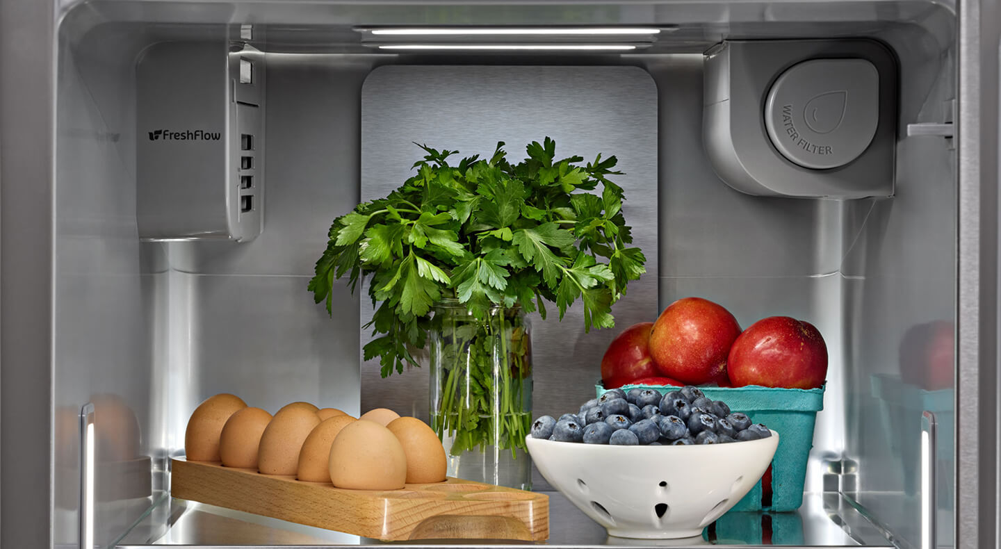 Bunch of cilantro stored with other fresh foods inside of a refrigerator