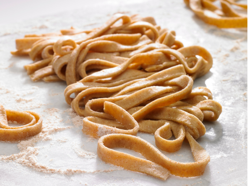 Nest of fresh fettuccine laying in flour