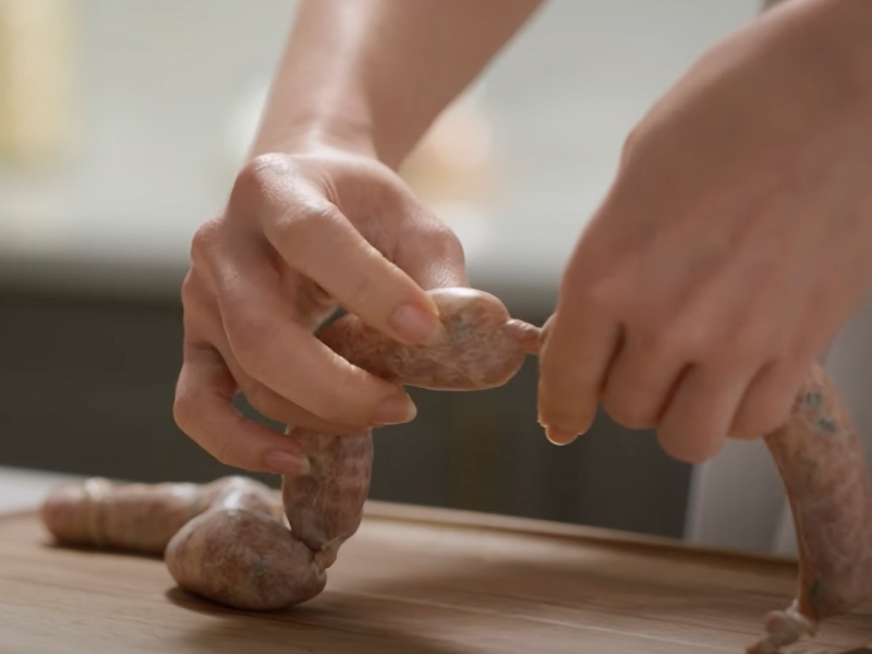 Person linking sausages