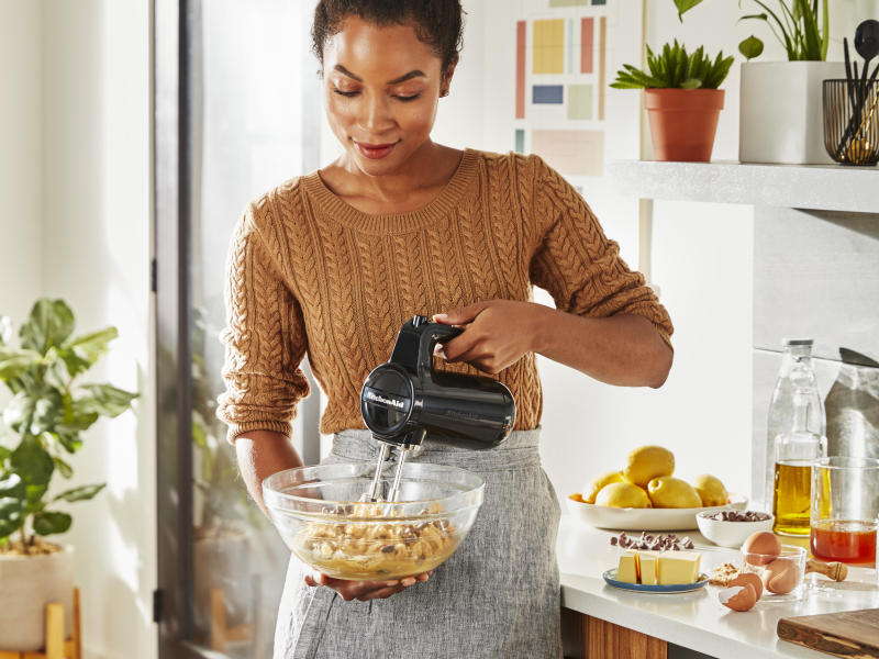 Person using KitchenAid® cordless hand mixer