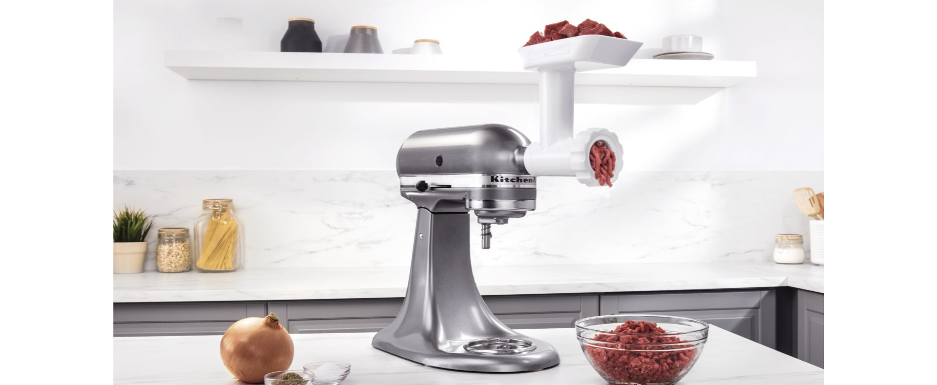 Silver stand mixer with white meat grinder attachment grinding beef