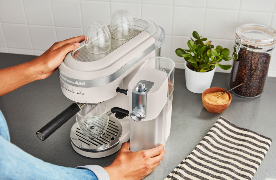 Person attaching automatic milk frother to KitchenAid® espresso machine