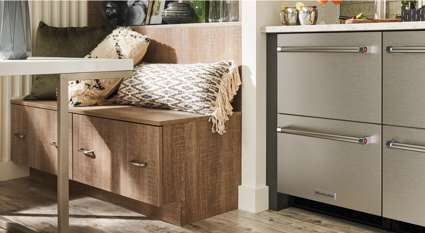 Breakfast nook next to KitchenAid® stainless steel undercounter refrigerator drawers