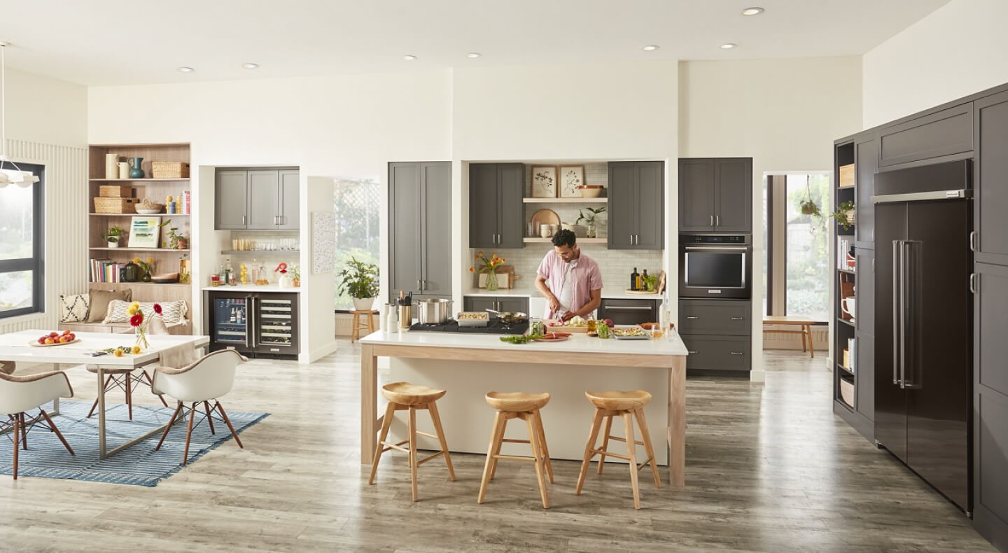 Person chopping produce on an island in modern kitchen