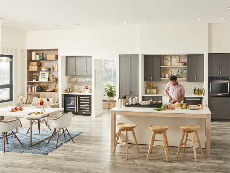 Person chopping produce on an island in modern kitchen